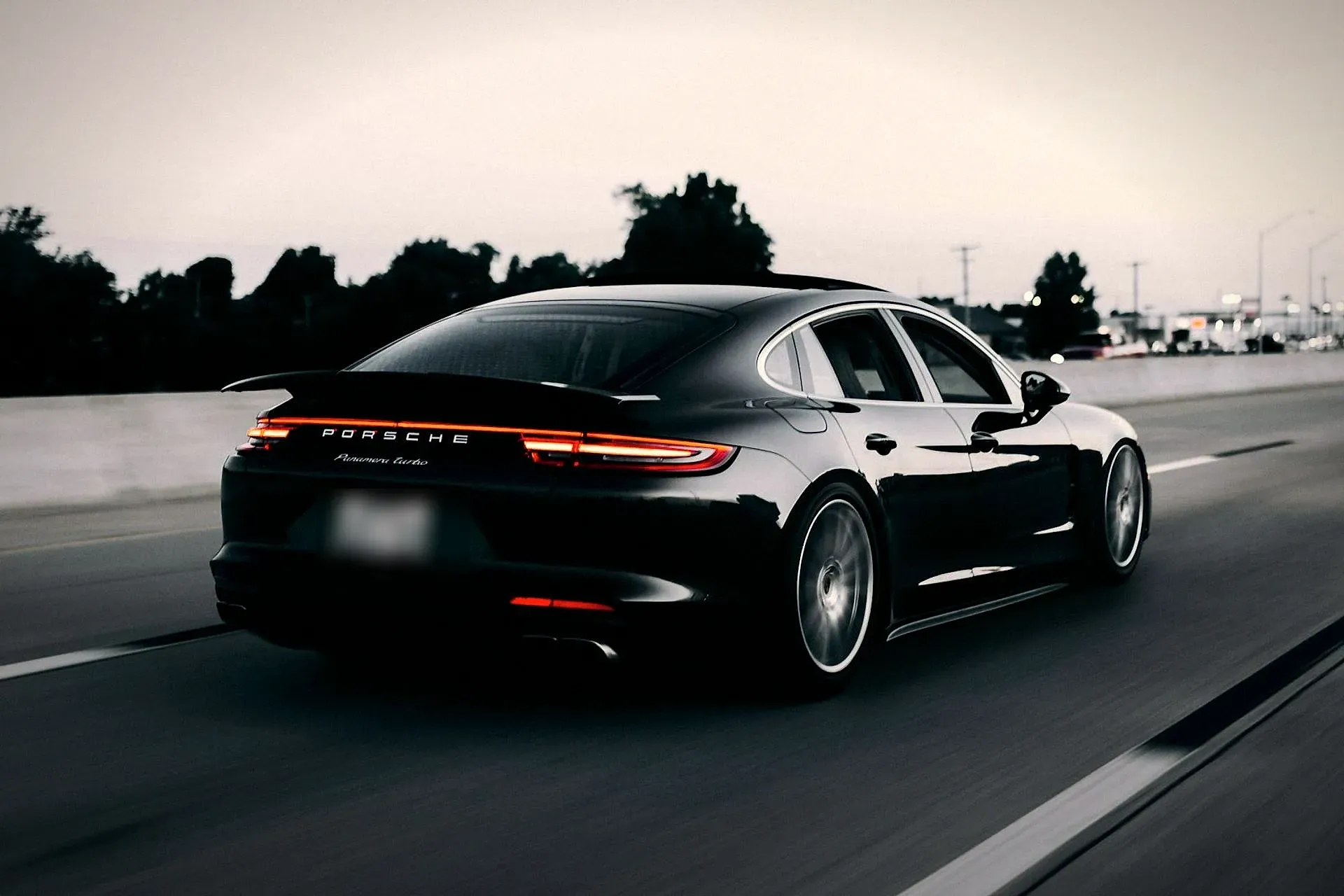 Black luxury sedan on the road at dusk